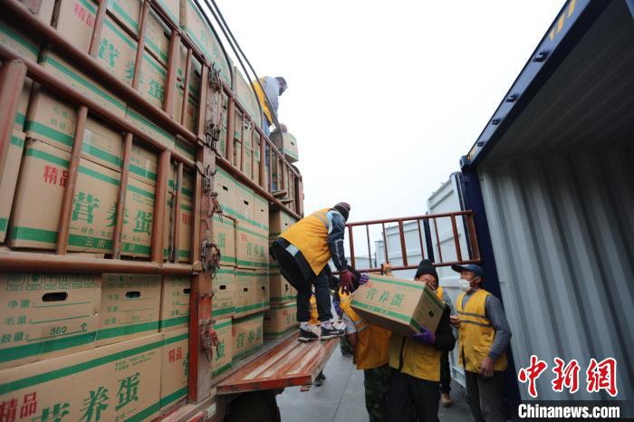 圖為鐵路裝卸作業(yè)人員正在將云南特色農產品裝入集裝箱?！詈?攝