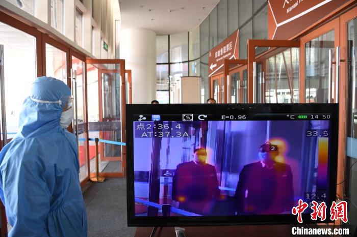 圖為游客步行通過(guò)紅外線(xiàn)測(cè)溫通道?！钇G敏 攝