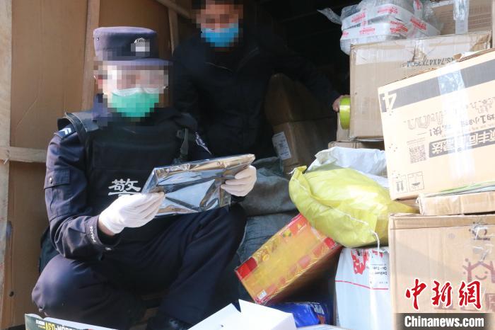 圖為勐康邊檢站民警在對(duì)快遞運(yùn)輸車輛進(jìn)行例行檢查?！钐?攝