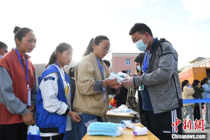 7月7日，考生在拉薩三高考點(diǎn)外領(lǐng)取口罩。　何蓬磊 攝